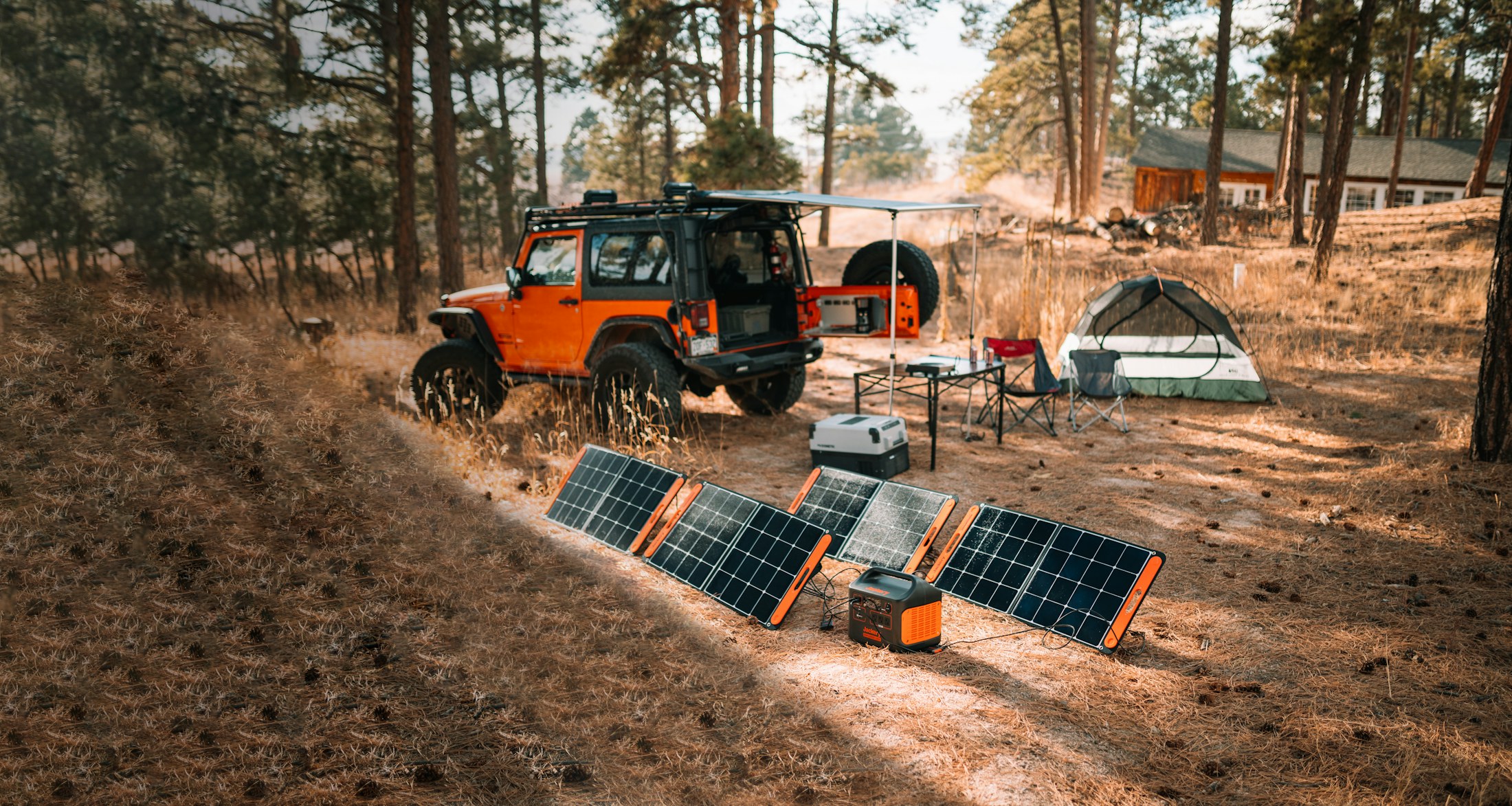 Portable solar panels and a battery at a campsite